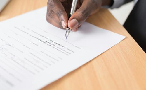 Person holding a pen signing a contract