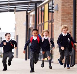 School building with young pupils running in front of it